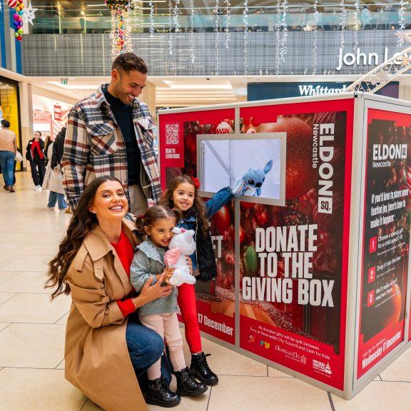 Family donating gift to mission Christmas